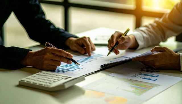 資料を見つつ打ち合わせをする2人の男性 | 愛知県の光学機器の設計・試作・測定 | 株式会社LABOPT